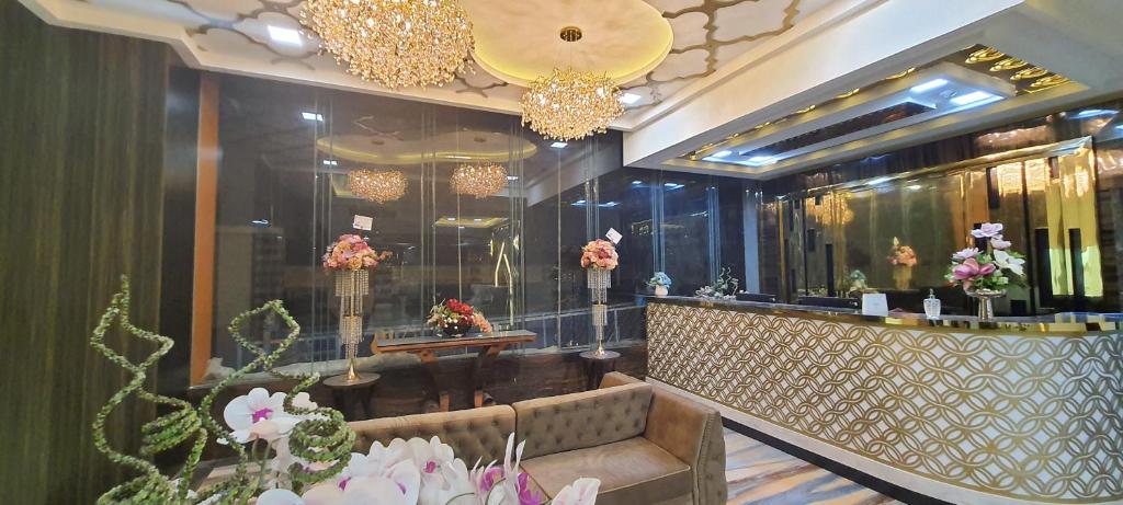 a lobby with a bar with flowers and chandeliers at Hotel Daily Inn Bandung in Bandung