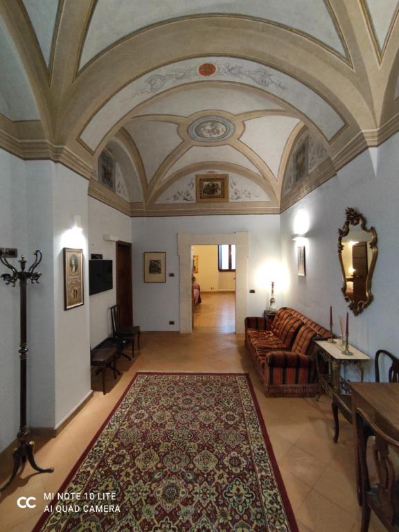 een woonkamer met een bank en een tapijt bij Palazzo Rustici b&b & apartments in LʼAquila