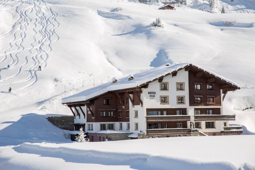 a building in the snow with snow at Hotel Ulli in Zürs am Arlberg