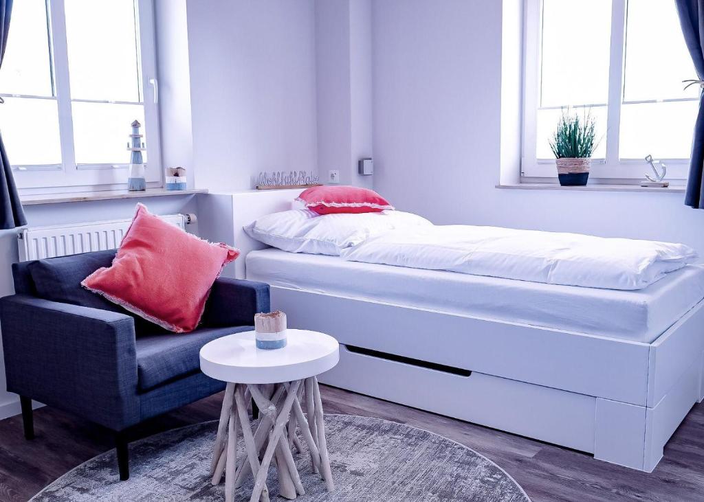 una camera con letto, sedia e tavolo di Flippi-s-Hues-NORD a Westerland