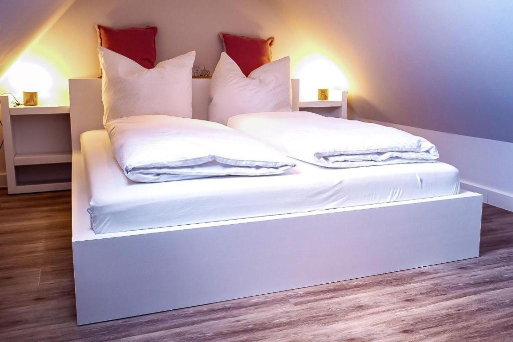 - un lit blanc avec des oreillers au-dessus dans l'établissement Flippi-s-Hues-WEST, à Westerland