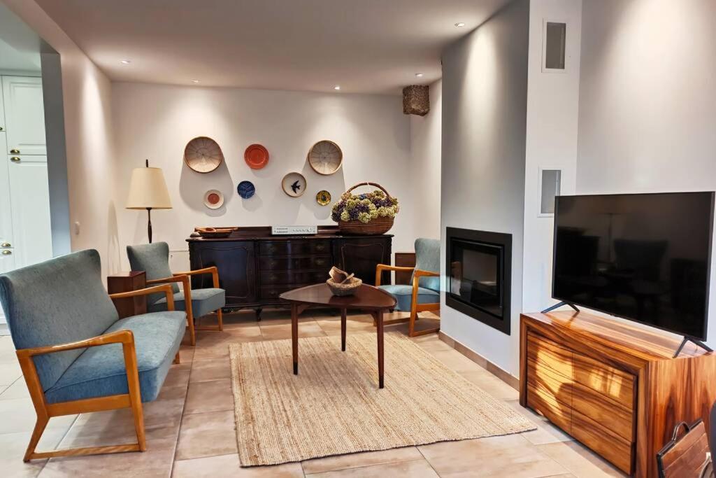 a living room with a tv and a couch and a table at Villa Tauria- Casa de campo em aldeia medieval in Sabugal