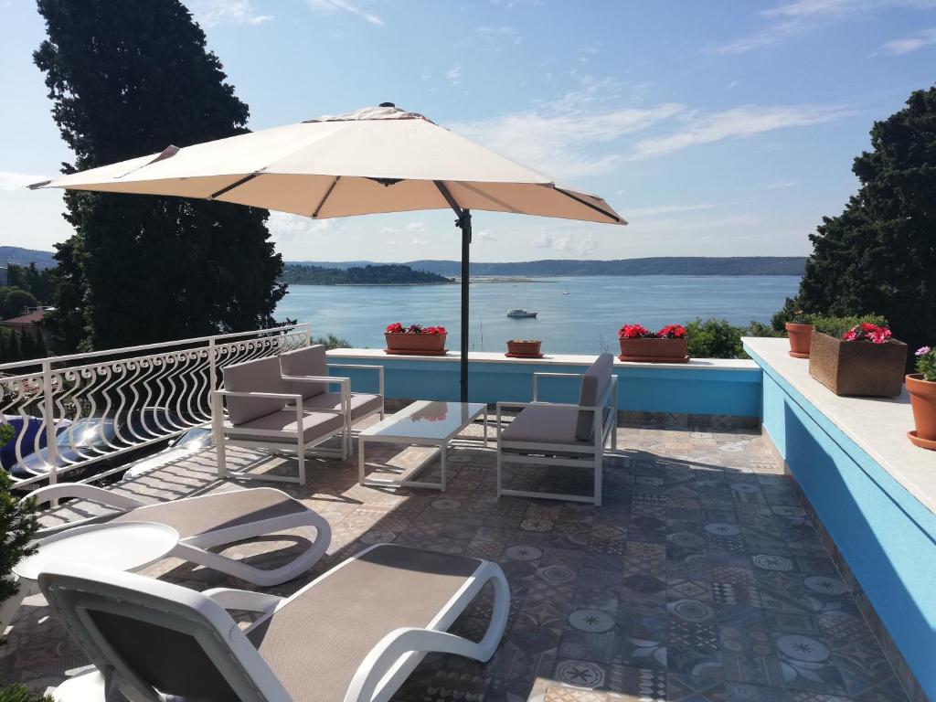 a patio with a table and chairs and an umbrella at Apartments & Rooms Matos in Portorož