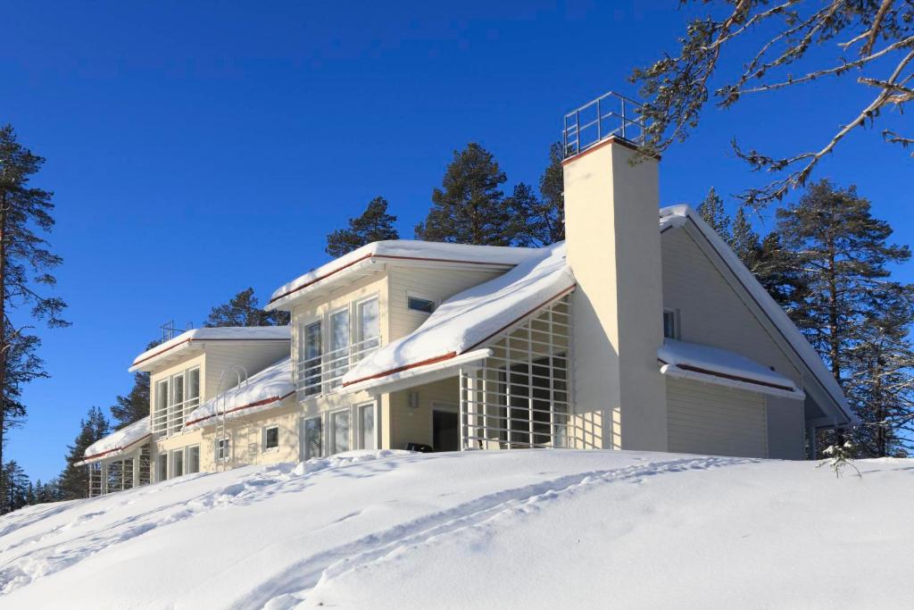 Una casa en la nieve en el bosque en Holiday Club Kuusamon Tropiikki Apartments en Kuusamo