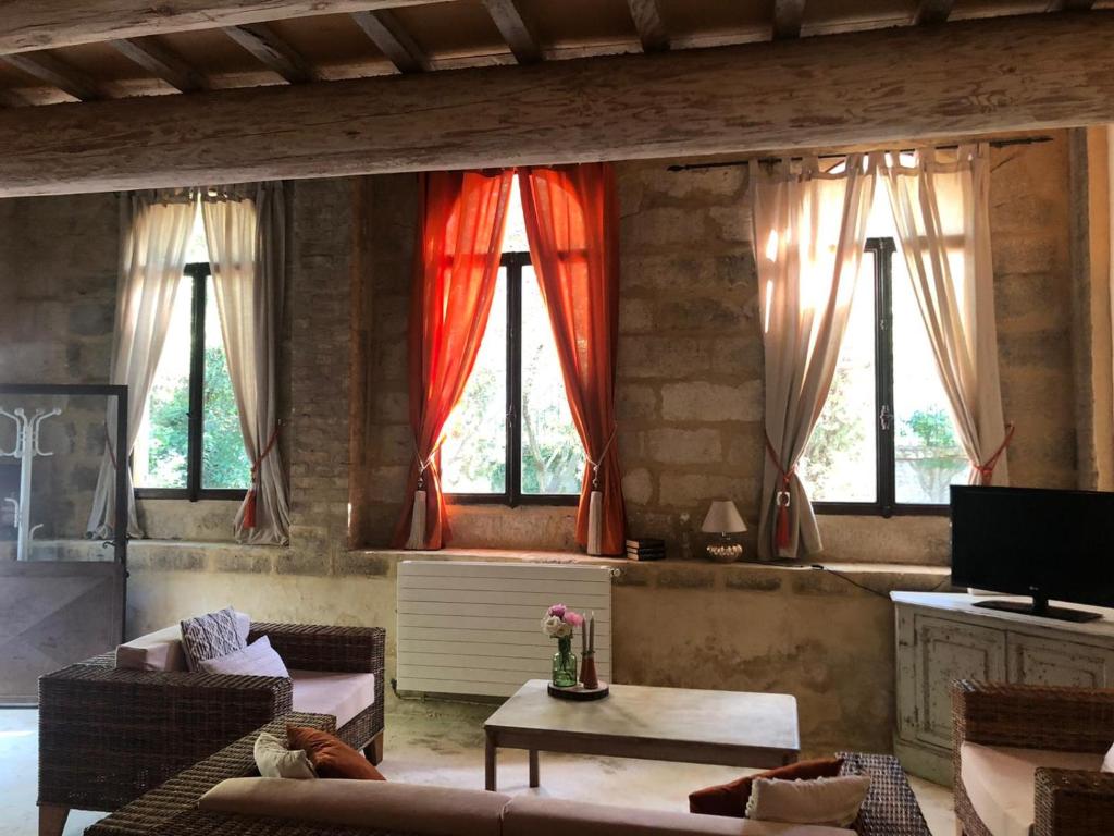 - un salon avec des rideaux rouges sur les fenêtres dans l'établissement Gîte de caractère 72m2, à Rochefort-du-Gard
