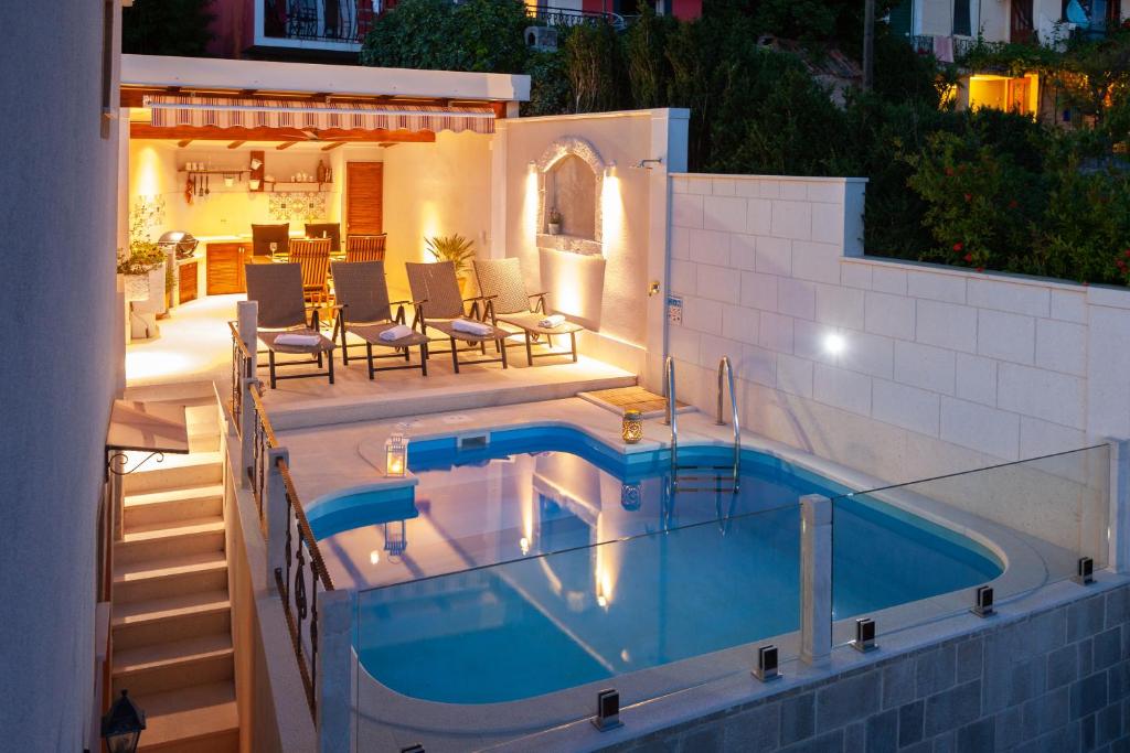 uma piscina ao lado de uma casa em Idyllic villa Marieta with private pool and unforgettable view em Makarska