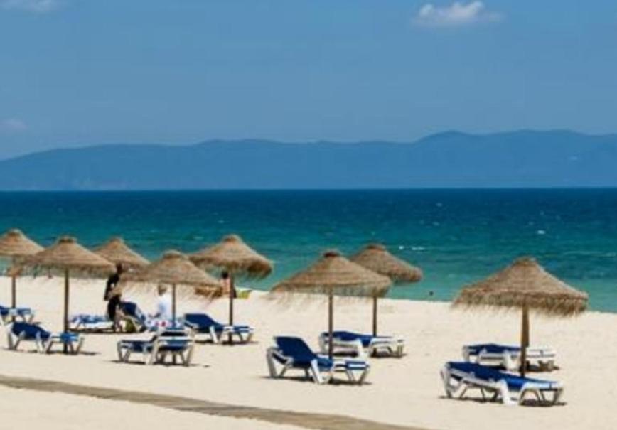 - un groupe de chaises longues et de parasols sur une plage dans l'établissement TRÓIA BOUTIQUE APARTMENT, à Tróia