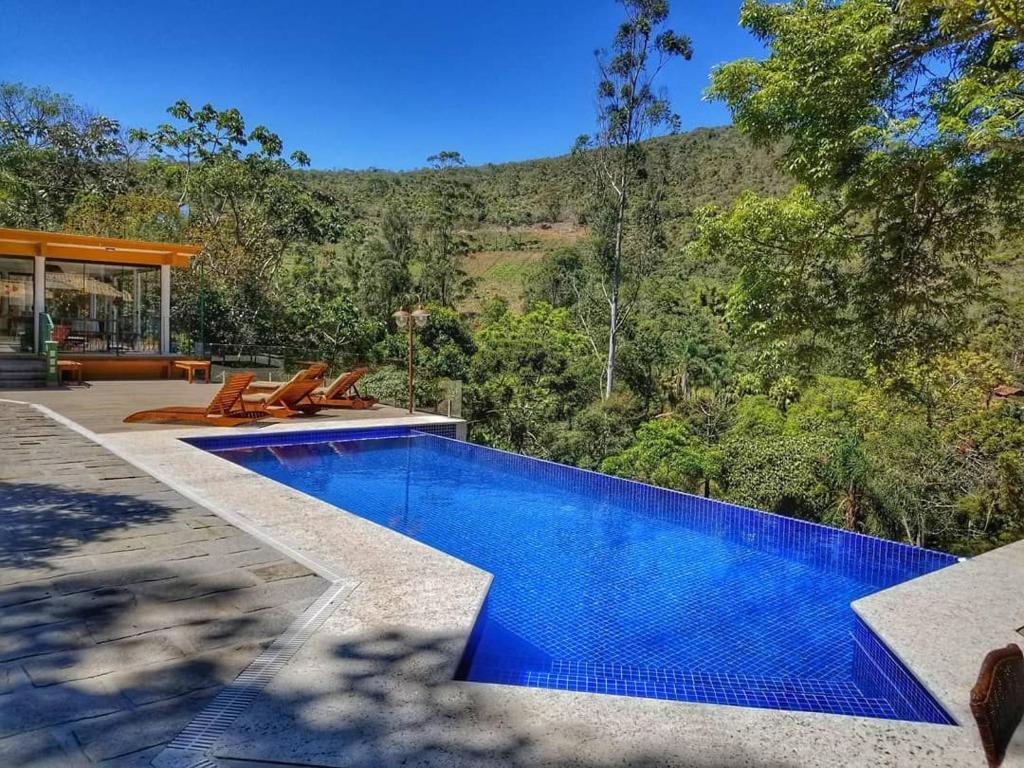 uma piscina no meio de um quintal em Sítio Vaca do Brejo, piscina aquecida, sauna, A/C quente e frio, jogos, playground em Petrópolis