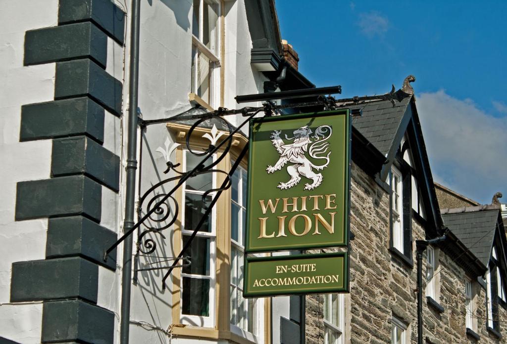 Znak dla białego lwa na boku budynku w obiekcie The White Lion Hotel w mieście Machynlleth