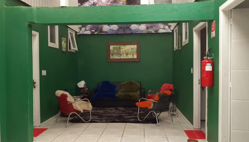 - un salon doté d'un mur vert avec une bouche de feu dans l'établissement Magias da Serra, à Canela