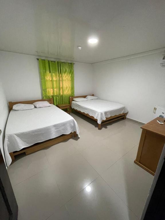 1 dormitorio con 2 camas, mesa y ventana en Posada Yasa sarie bay en San Andrés