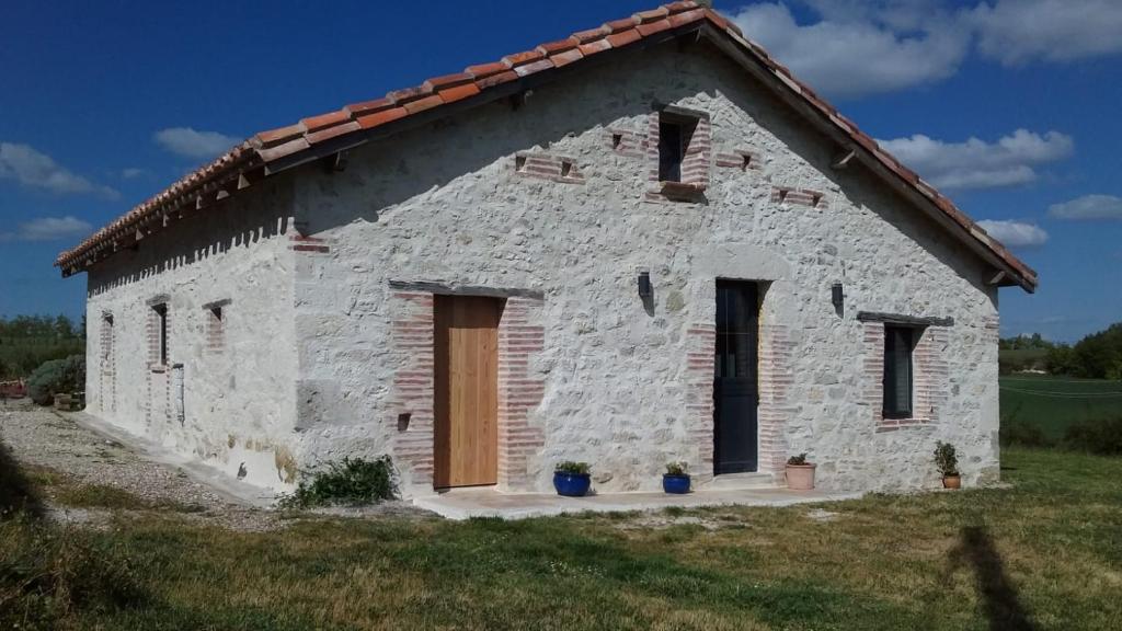 una casa de piedra con techo rojo en Villa rurale, en Cazes-Mondenard