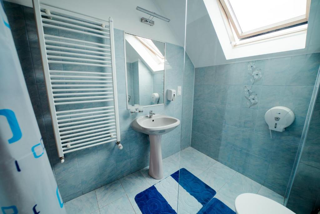 a bathroom with a sink and a mirror and a toilet at Nagy-Homoród Étterem és Panzió in Rareş