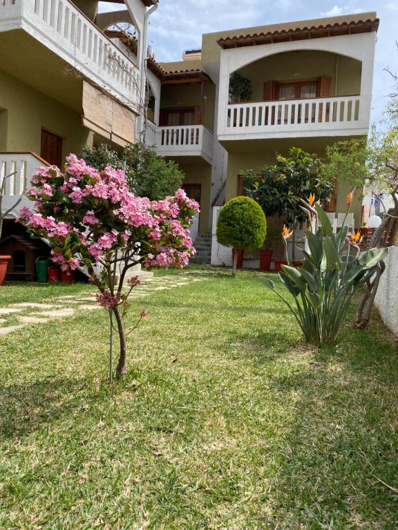a house with pink flowers in the yard at Nicolas Beach in Palaiochora
