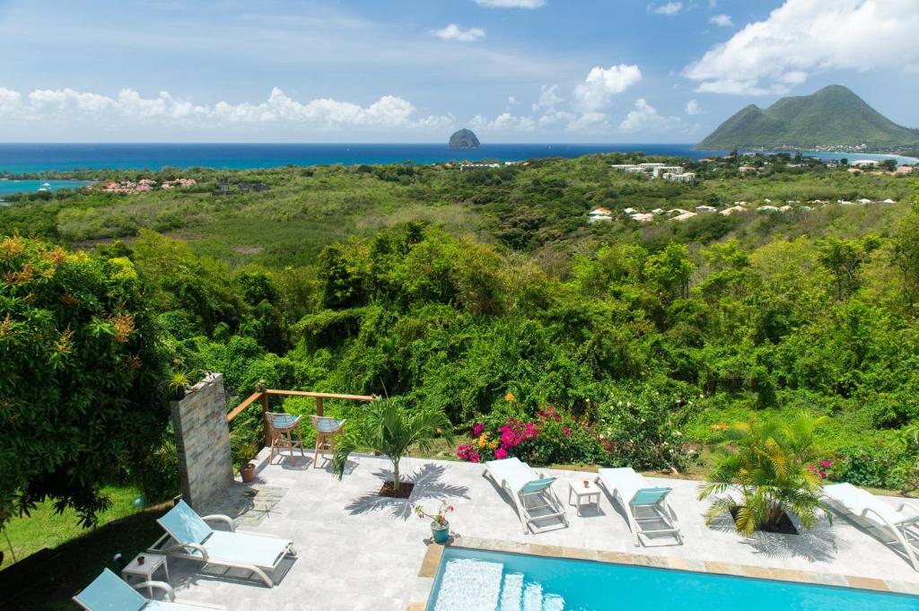 a resort with a pool and a view of the ocean at Kaz O'Rocher - Sea View Appartements in Le Diamant