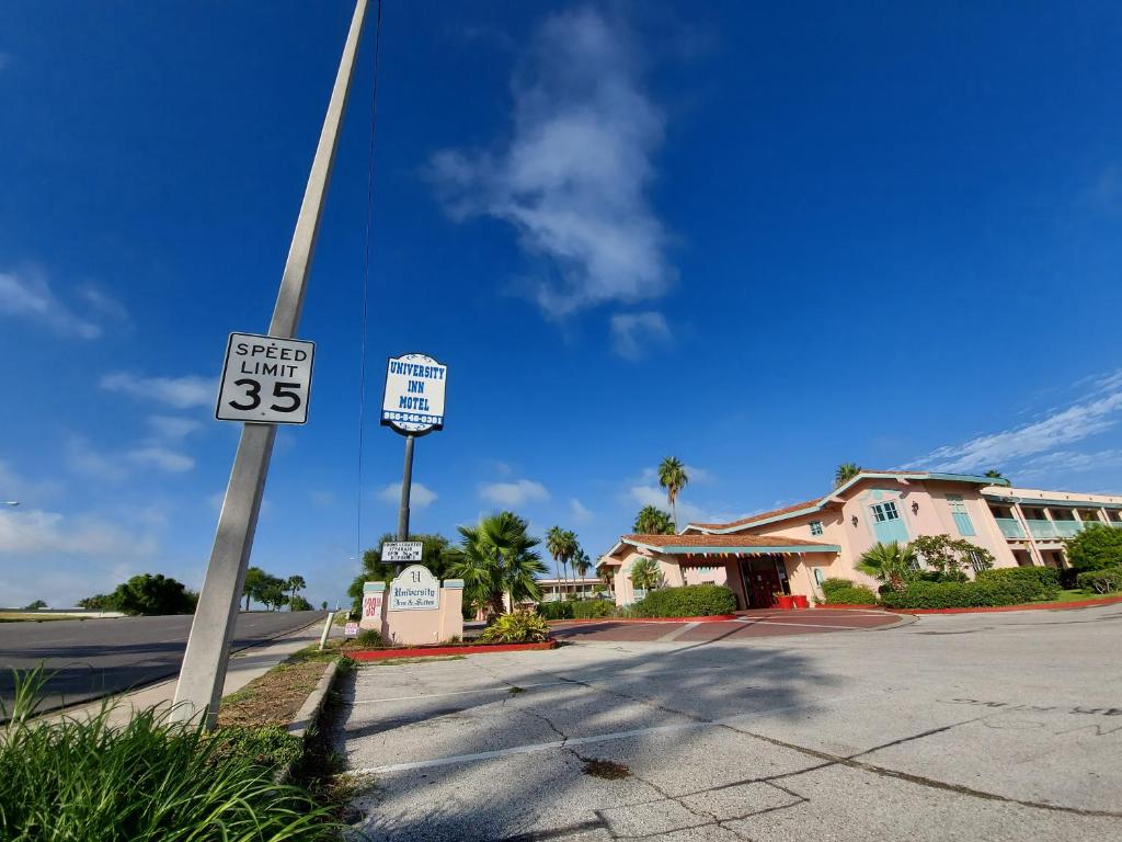 un letrero de calle con una señal de límite de velocidad en una calle en University Inn & Suites Brownsville, en Brownsville