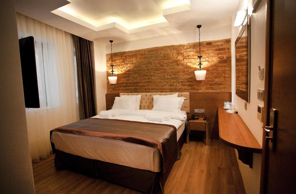 a bedroom with a bed and a brick wall at Pera Line Hotel in Istanbul