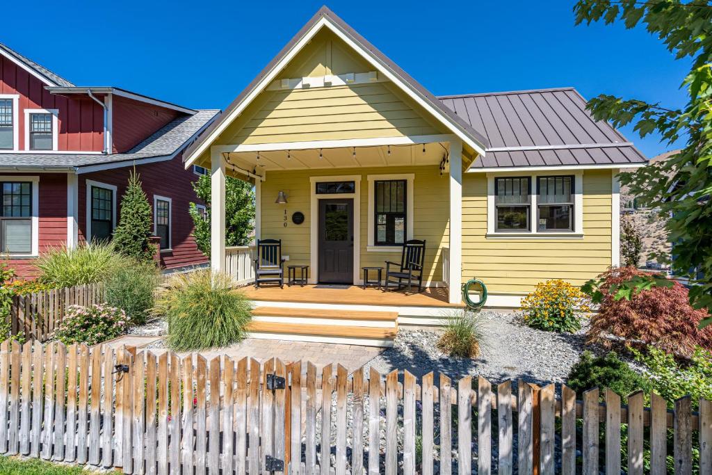 a yellow house with a fence in front of it at Northern Lights #71 in Chelan