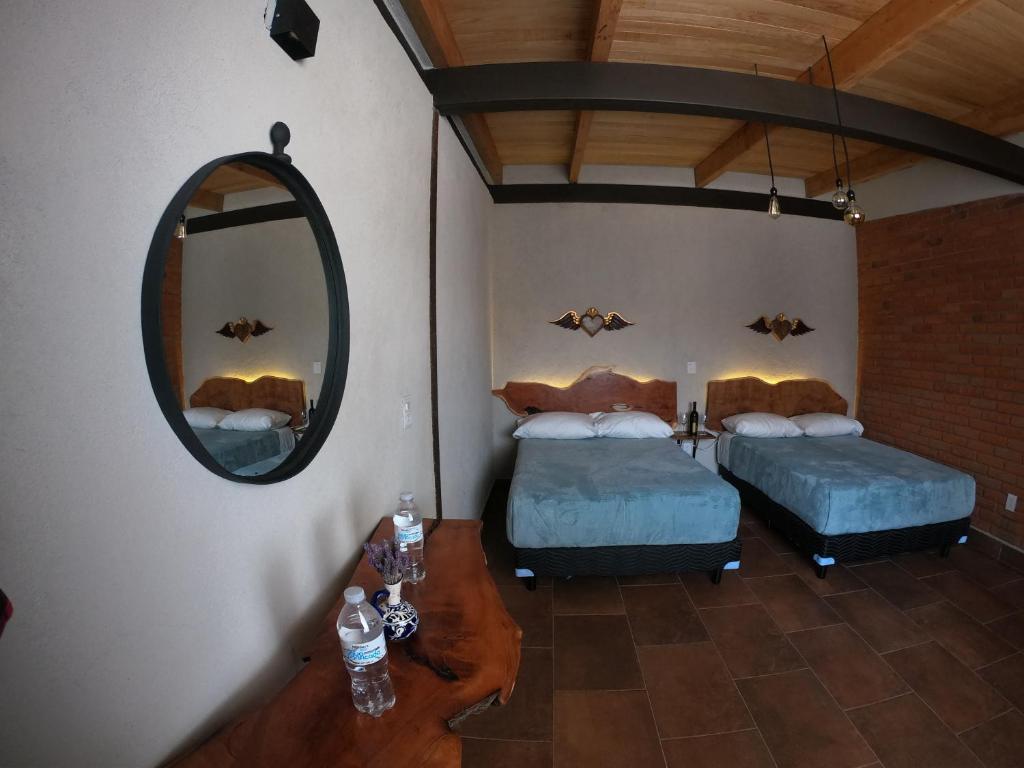 Vista aérea de un dormitorio con 2 camas y espejo en Hotel Viñedo los Arcángeles en Dolores Hidalgo