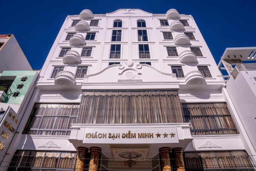 un edificio blanco alto con un letrero. en Khách Sạn Diễm Minh, en Can Tho