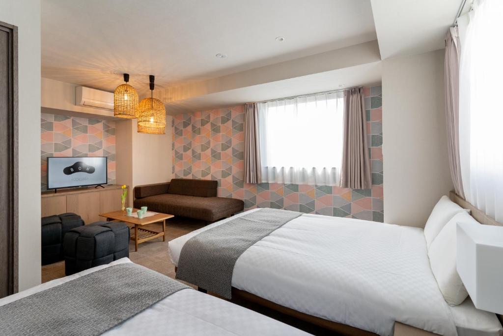 a hotel room with two beds and a couch at BON Kyoto Kiyomizu in Kyoto
