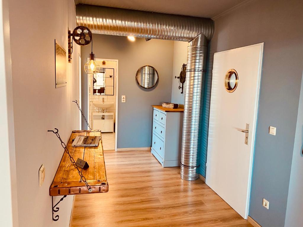 a hallway with a wooden table in a room at COAST HOUSE River Docks in Bremerhaven