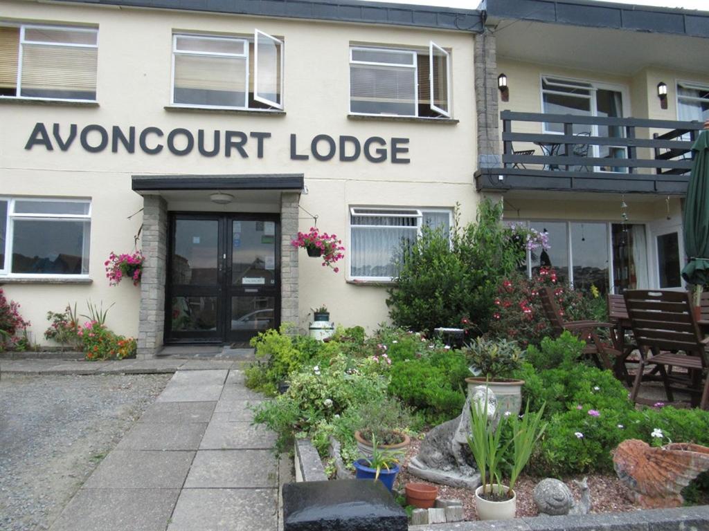 un edificio blanco con un cartel que lee toda la noche lodge en Avoncourt Lodge en Ilfracombe