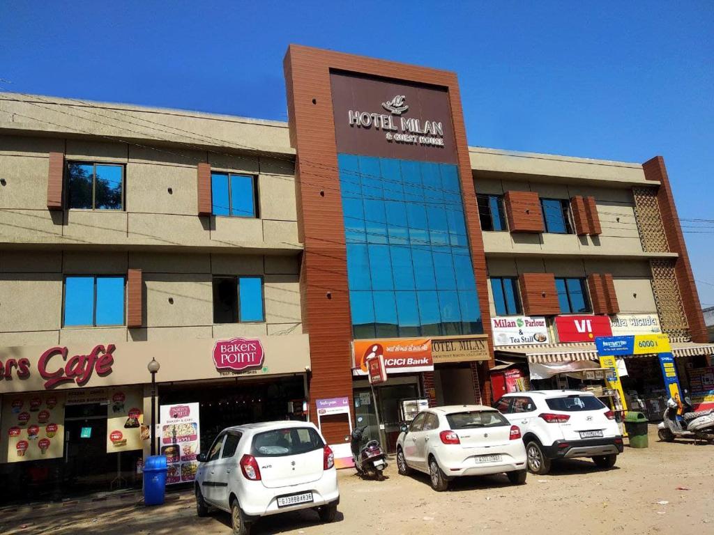 a building with cars parked in a parking lot at Hotel Milan in Ahmedabad