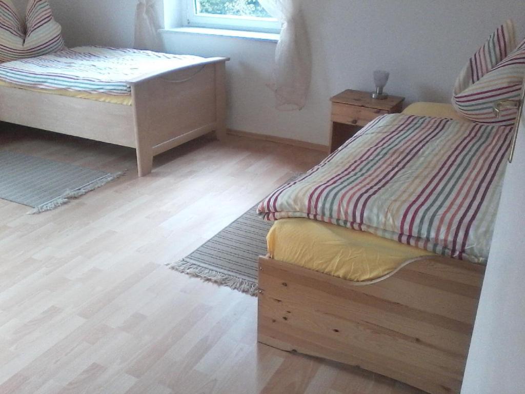 Cette chambre comprend 2 lits jumeaux et une fenêtre. dans l'établissement Ferienwohnungen Bernd Krügel, à Zwickau