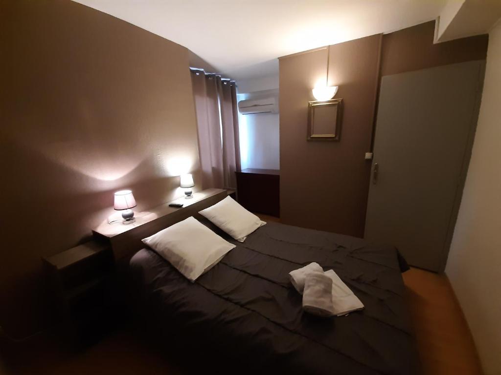מיטה או מיטות בחדר ב-Hôtel Le Passage de Vallon