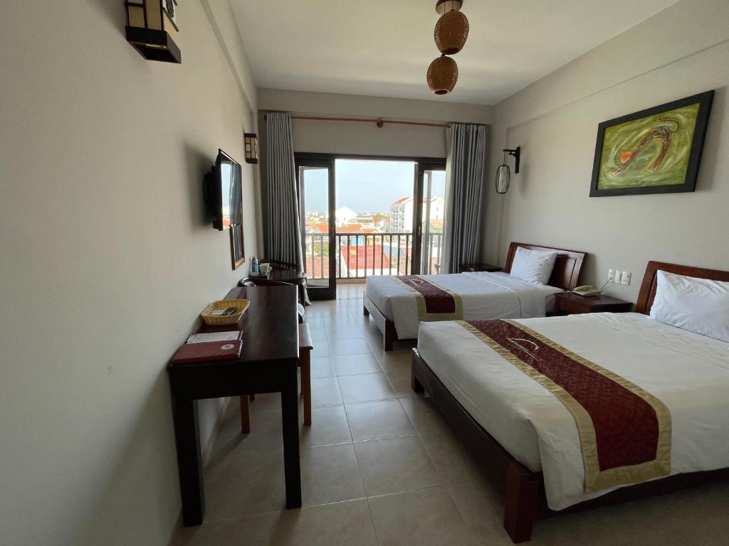 Postel nebo postele na pokoji v ubytování Sunshine Hoian Hotel
