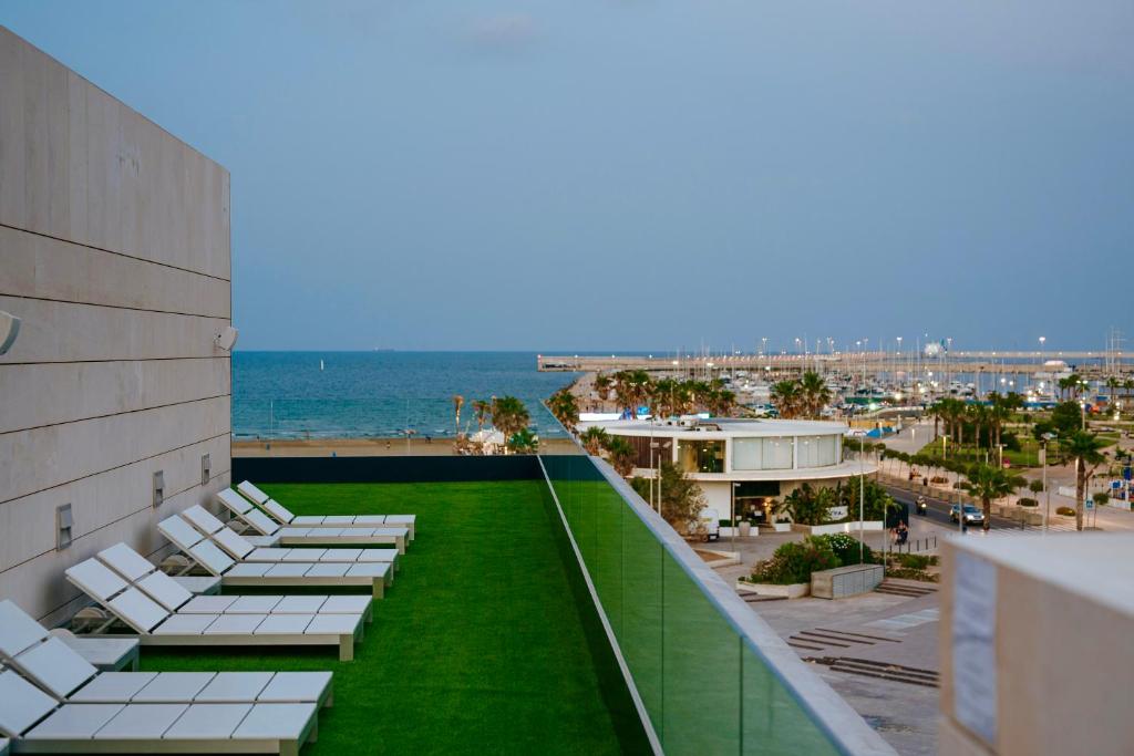 a row of lounge chairs on the roof of a building at Hotel Neptuno Playa & Spa in Valencia
