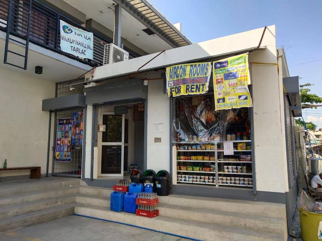 una tienda frente a una tienda de comestibles con carteles en ella en KDorm, en Tarlac
