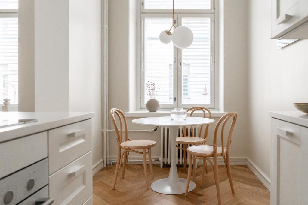 kuchnia ze stołem i krzesłami oraz oknem w obiekcie Roost Roobert 3 w Helsinkach