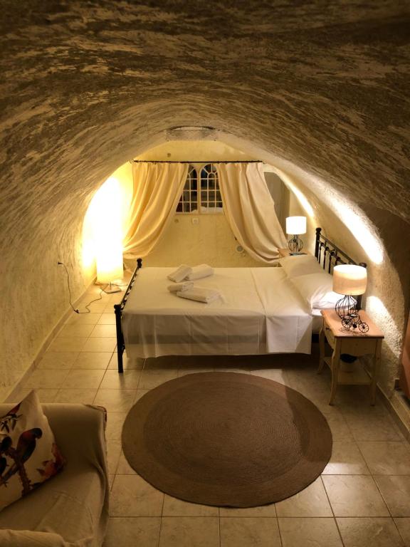 a bedroom with a bed and a couch in a tunnel at Kamares Cave House 3 in Álika