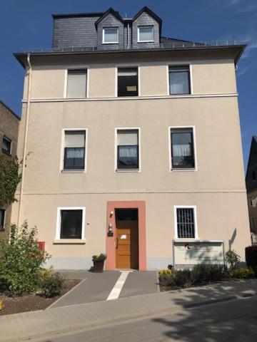 a large white building with a red door at Hildegard Forum in Bingen am Rhein