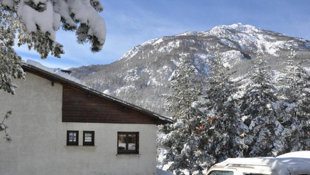 a house in front of a snow covered mountain at Chalet Nicouski in La Salle Les Alpes