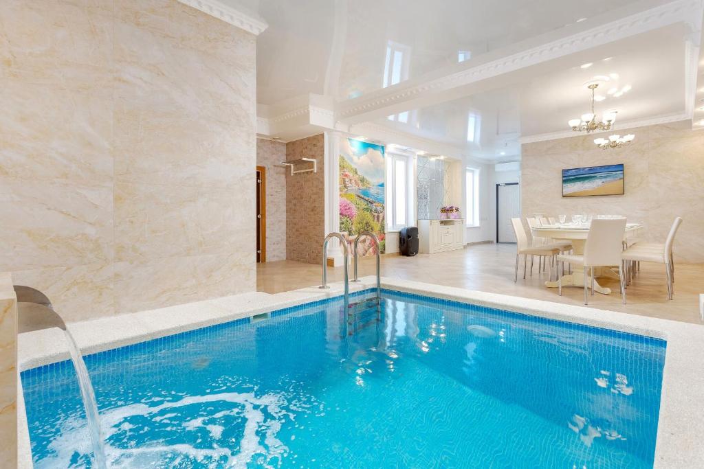 克拉斯諾達爾的住宿－Home-otel，一个带用餐室的房间内的大型游泳池