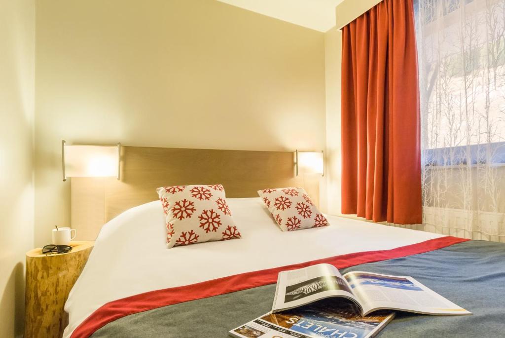 a hotel room with a bed with a book on it at Résidence Pierre & Vacances Atria-Crozats in Avoriaz
