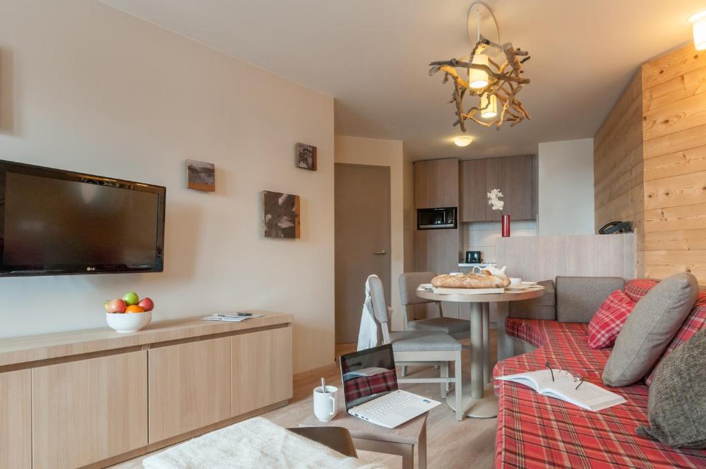 a living room with a couch and a table with a laptop at Résidence Pierre & Vacances Atria-Crozats in Avoriaz