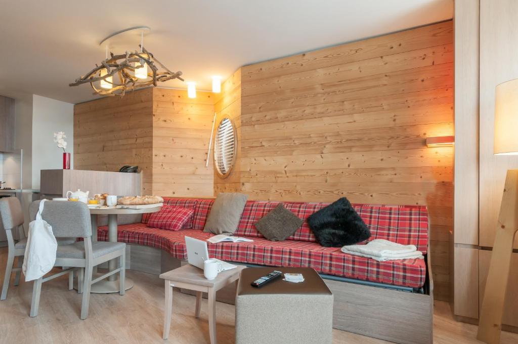 a living room with a red couch and a table at Résidence Pierre & Vacances Atria-Crozats in Avoriaz