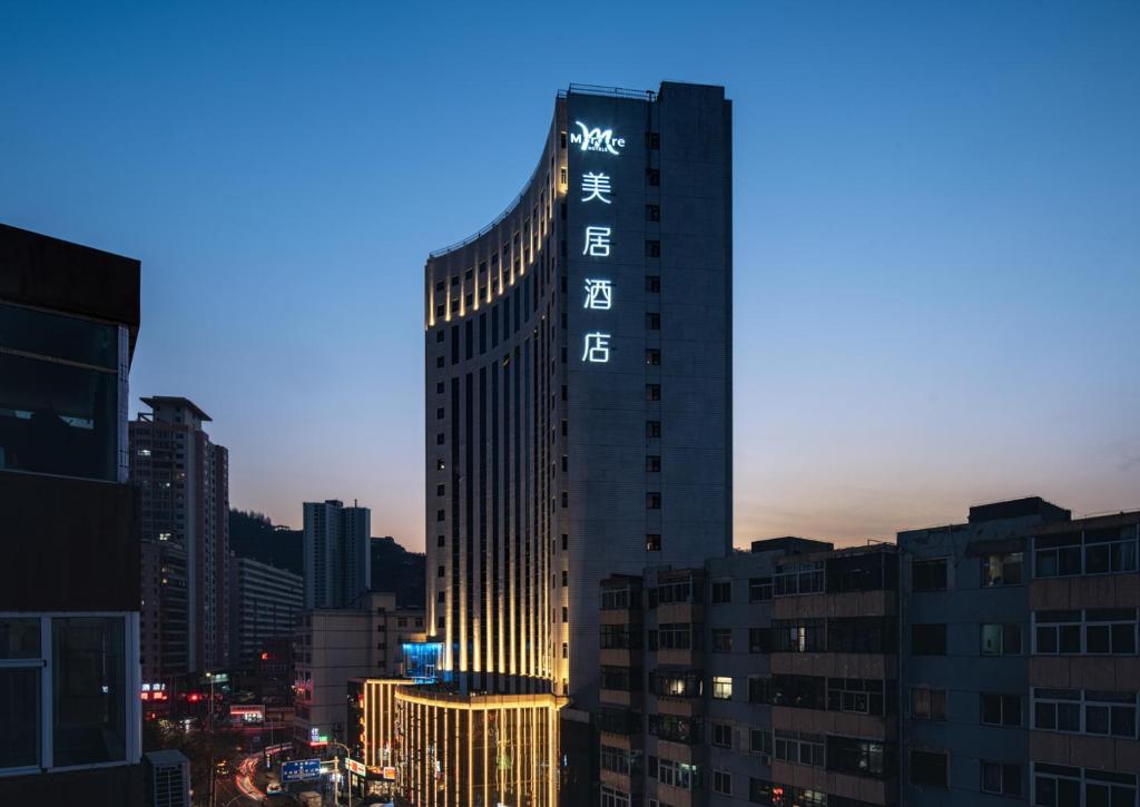 un edificio alto con un cartel en una ciudad en Mercure Lanzhou Zhengning Road, en Lanzhou