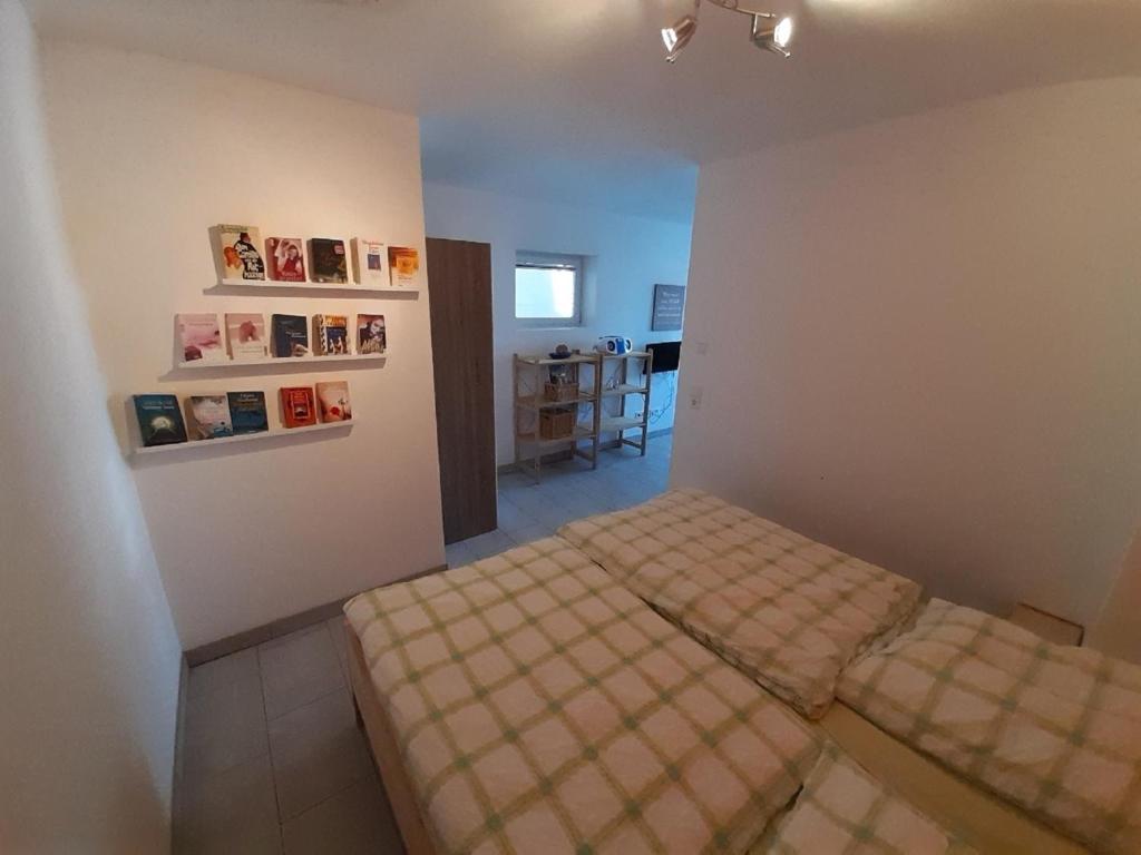 ein kleines Schlafzimmer mit einem Bett und einem Tisch in der Unterkunft Ferienwohnung Goltz in Thüngersheim