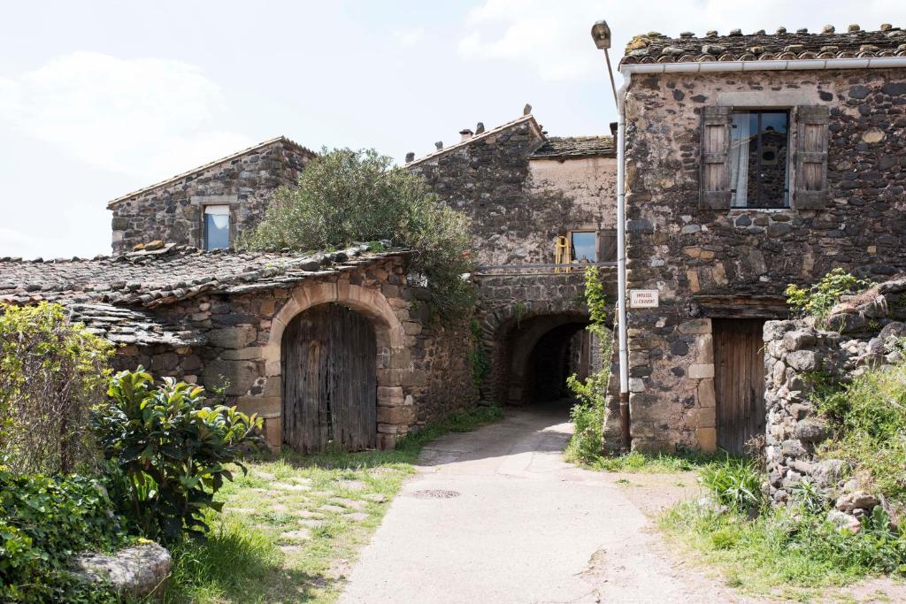 an old stone building with two doors and an alley at Octon - Le Couvent in Octon