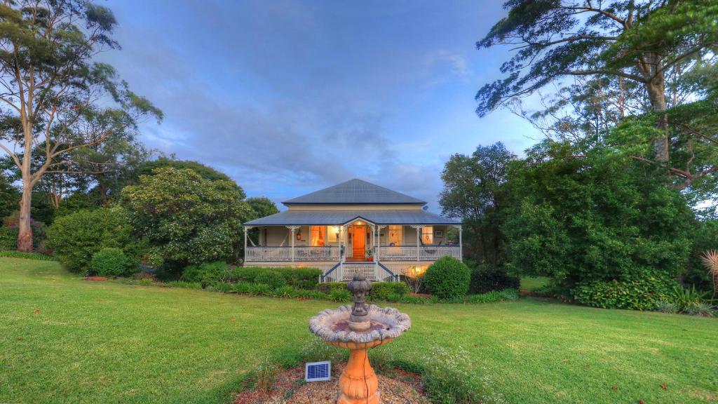 a house with a fountain in the middle of a yard at Mitta Glen GuestHouse in Flaxton