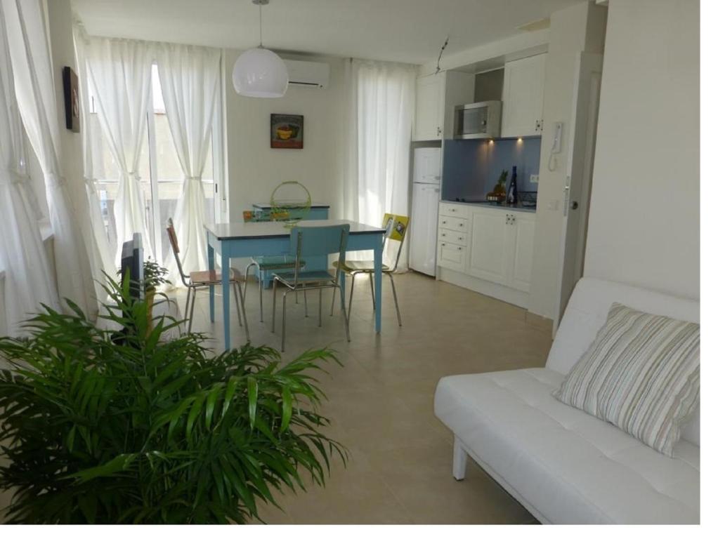 a living room with a couch and a table and chairs at Apartamento céntrico cerca de la playa in L'Ametlla de Mar