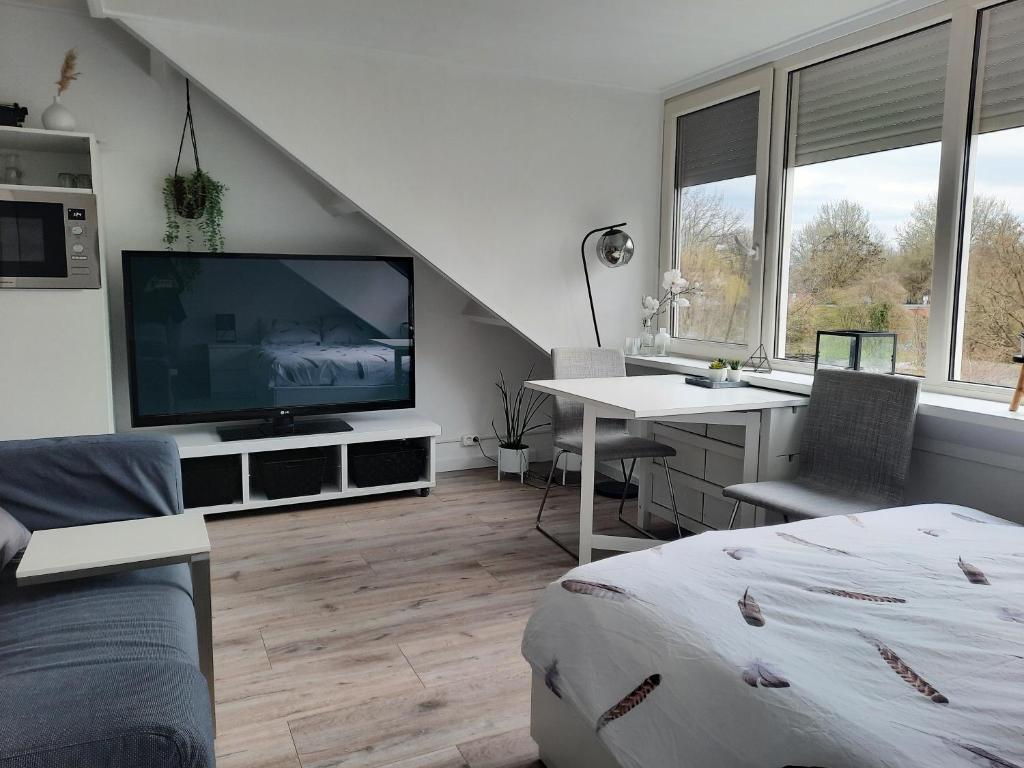 Studio 76 Groningen met gratis leenfietsen في خرونينغن: غرفة معيشة مع تلفزيون كبير وسرير