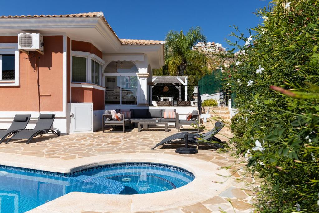 a backyard with a swimming pool and a house at Casa de Familia in Muchamiel