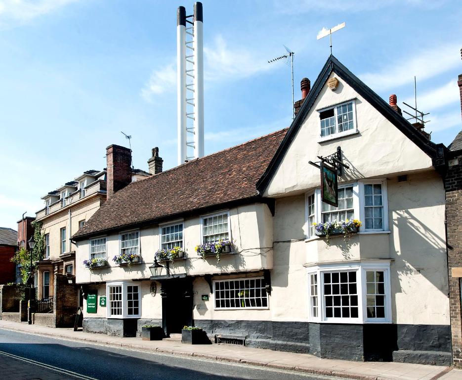 a white building on the side of a street at Dog and Partridge by Greene King Inns in Bury Saint Edmunds