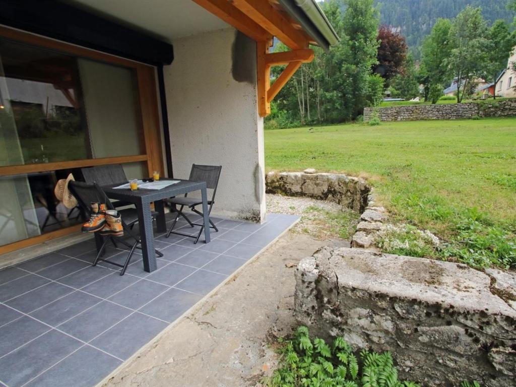 eine Terrasse mit einem Tisch und Stühlen außerhalb eines Hauses in der Unterkunft Les Berlicants in Mijoux